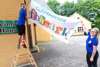 Disco, Flohmarkt, Meppelrennen - auf zum 573. Jahrmarkt in Clausnitz! - Mitmacher gesucht: Tim Funke und Annika Meyer hängen das Flohmarkt-Banner auf.