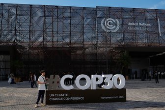 Doch, wir machen weiter, es lohnt sich – ein Kommentar zur Klimakonferenz - Eine Person posiert für ein Foto mit einem Schild für den UN-Klimagipfel COP30. Der Gipfel beginnt am 11. November.