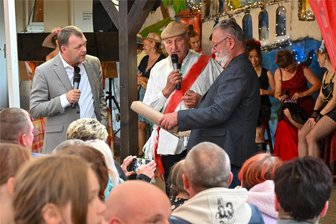 Dolce Vita an der Aue: Niederlichtenau feiert seine Geschichte und Solidarität seit der Flut von 2002 - Lichtenaus Bürgermeister Andreas Graf (links) spielt sich beim Abendprogramm zum 22. Dorffest in Niederlichtenau selbst, nicht zum ersten Mal. Dieses Mal will er in Italien Tipps zum Hochwasserschutz erhalten: bei Venedigs Bürgermeister (Hans-Joachim Richter), rechts der gespielte Lichtenauer Kämmerer (Mathias Ernstberger).