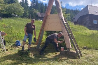 Dorf im Erzgebirge putzt sich heraus: Tellerhäuser feiert am Wochenende Ortsjubiläum - Rechtzeitig vor der 400-Jahr-Feier wurden neue Ortseingangssymbole angefertigt und aufgestellt. Die Wahl-Tellerhäuser Johannes Ferg (l.) und Jörg Schettler gaben der Holzkonstruktion – hier noch ohne Schmuckelemente – am Ortseingang aus Richtung Rittersgrün den letzten Schliff.