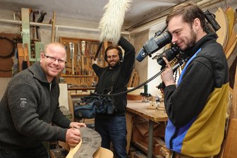 Dorf im Erzgebirge vor der MDR-Kamera: Harfenbauer gewährt Einblicke in seltenes Kunsthandwerk - Dem Meister des Harfenbaus direkt auf die Finger schauen, auch das wollte das MDR-Drehteam – Kameramann Christian Wohlfarth (r.) und Tontechniker Florian Krebs – in Pöhla.