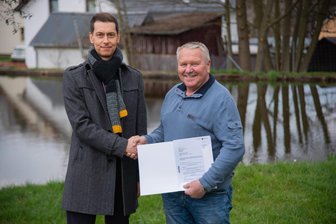 Dorf im Vogtland kann Großvorhaben endlich anpacken - Béla Beláfi, Präsident der Landesdirektion, übergibt Geld an Bürgermeister Stephan Meinel.