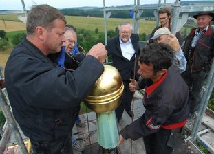 Dorfkirche in Oberwinkel hat wieder Kreuz und Kugel -
<p class="artikelinhalt">Ein bewegender Moment für die Kirchgemeinde: Dachdeckermeister Frank Schrepel (links) aus Reichenbach setzt mit seinem Gesellen Hans-Joachim Güttler die Kugel auf.</p>