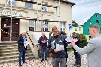 Dorfwettbewerb im Erzgebirge: Wie Börnichen bei der Jury punkten will - Vor dem Rundgang teilt Julian Helwig (3. v. l.) Pläne mit den Stationen des Rundganges aus. Links Bürgermeister Frank Lohr.