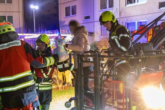 Dramatische Szenen bei Brand im Erzgebirge: Menschen müssen mit der Drehleiter aus Plattenbau-Wohnung gerettet werden - Die Feuerwehr rettete in der Nacht zu Sonntag mehrere Personen aus einer brennenden Wohnung.