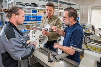 Drechselzentrum Erzgebirge expandiert ins Gewerbegebiet - Robin Leonhardt bespricht mit Roland und Martin Steinert (v. l.) bei der Montage einer Drechselbank ein technisches Detail.