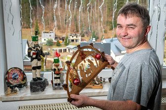 Drei Familien – ein Schicksal: Nach Wohnhausbrand kein Weihnachten für Erzgebirger in eigenen vier Wänden - Auf dem Fensterbrett stehen einige Weihnachtssachen, die Ingo Krauß aus der Brandruine retten konnte. Aus dem Wohnzimmerfenster seiner Übergangswohnung hat der Pobershauer freien Blick auf sein beim Brand zerstörtes Anwesen.
