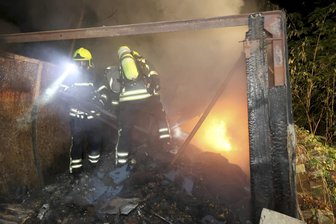 Drei Garagen in Flammen: Brandstifter in Chemnitz am Werk - Alarmierte Feuerwehrleute beim Löschen in einer der Garagen.
