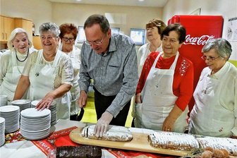 Drei Jahrzehnte hilfreich im Einsatz: Weißenborner Landfrauen begehen Jubiläum - Die Landfrauen schauen Bürgermeister Udo Eckert beim Stollenanschnitt zu. 