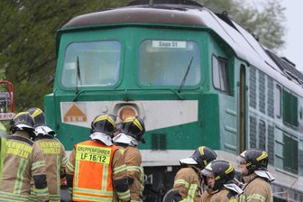 Drei Menschen sterben bei Zusammenstoß mit Güterzug - Rettungskräfte stehen an der Bahnstrecke bei Lohma (Thüringen) vor der Lokomotive eines Güterzugs. Beim Zusammenstoß des Güterzugs mit einem Auto sind drei Menschen ums Leben gekommen.