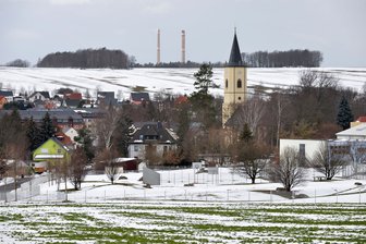Dreikampf in Bobritzsch-Hilbersdorf - Die Kirche in Niederbobritzsch prägt die Silhouette des Ortes. Der Westturm wurde erst im Jahr 1853 errichtet, doch die Saalkirche ist älteren Datums. Die Jahreszahl 1513, die in einem Strebepfeiler zu finden ist, weist auf die Entstehungszeit hin. Im Hintergrund sind die Schlote von Muldenhütten zu erkennen.