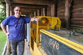 Dringend gesucht: Schaubergwerk im Erzgebirge braucht neue Bergführer - Sebastian Schieck ist Vorsitzender des Vereins Interessengemeinschaft Historischer Bergbau Zschorlau. Die Bahn, an der er lehnt, kam im historischen Silberbergbau nie zum Einsatz.