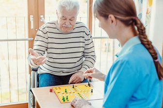 Drohender Personalmangel in der Altenpflege: Freiwillige als Notfallreserve? - Freiwillige Helfer haben - wie auf diesem Symbolbild - oft Zeit für Gesellschaftsspiele, Vorleserunden oder andere Angebote der sozialen Teilhabe. Bei Personalnot sollen sie verstärkt auch Pflegekräfte unterstützen.