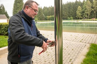 Durchwachsener Sommer lockt weniger Besucher in Freibäder - Techniker Heiko Walther macht das Waldbad Rätzteich winterfest. Dazu gehört unter anderem, die Funktionsteile der Außenduschen auszutauschen.