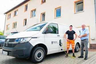 E-Autos in Mittelsachsen: Anzahl der Neuzulassungen wächst nicht mehr so rasant - Robert Winkler (links) und Bürgermeister Dietmar Gottwald mit dem VW-Transporter, der inzwischen den Streetscooter des Rossauer Bauhofs ersetzt hat. Um die 60 bis 80 Kilometer werden mit dem Nutzfahrzeug mit einer Akkuladung gefahren.