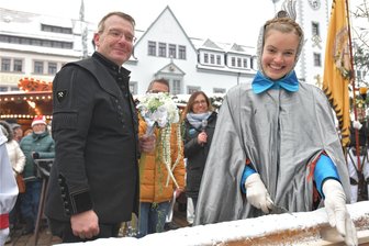 Echter Erzgebirgsstollen geht auf dem Christmarkt in Freiberg weg wie warme Semmeln - Zum Stollenanschnitt am Samstag auf dem Freiberger Obermarkt: Oberbürgermeister Sven Krüger und Silberstadtkönigin Sophia schnitten das Riesenbackwerk an.