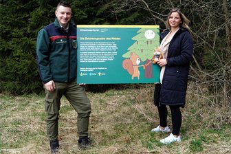Ecki’s Naturlehrpfad entsteht im Erholungsgebiet am Meiler in Schöneck - Jennifer Braun, Geschäftsführerin der Schönecker DLT, und David Neubert vom Forstbezirk Adorf mit einer der 14 Tafeln für den neuen Lehrpfad im Schönecker Meilergebiet - und Maskottchen Ecki. Seit zwei Jahren arbeiten Stadt und Sachsenforst bei dem Vorhaben eng zusammen. Am 8. Juni soll der Lehrpfad eingeweiht werden.