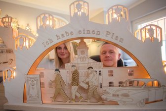 Egon Olsen - vom Knast auf den Schwibbogen - René Weinhold und Jane Kaden mit dem Olsenbande-Schwibbogen. Untergebracht sind dort unter anderem Egon Olsen, Benny Frandsen und KjeldJensen, die zielgerichtet auf den Tresor der Marke "Franz Jäger, Berlin" zuschreiten. 