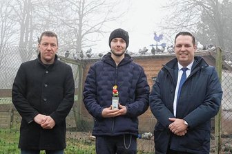 Ehrenamt des Monats: Jonas Wagler hat ein Herz für Hühner und Tauben - Der Preisträger und Tierschützer Jonas Wagler (M.) präsentiert sich mit der Trophäe und dem stellvertretenden Bürgermeister von Jöhstadt Daniel Meyer (l.) und Landrat Rico Anton. 