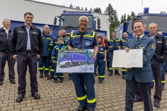 Ehrenamtliche Arbeit im THW hält Senior unter Spannung - Überraschung geglückt: Viele Kameraden des Ortsverbands Annaberg des Technischen Hilfswerks waren dabei, als Klaus Hauschild (Mitte) aus Anlass seines 80. Geburtstags von Sven Hoppe (rechts), dem Leiter der TWH-Regionalstelle Chemnitz, geehrt wurde. 