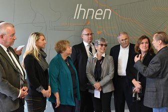 Ehrengäste bei den Shalom-Tagen - Mary Olsky, Thomas Berger, die KZ-Babys Hana Berger Moran und Mark Olsky sowie Autorin Wendy Holden mit Michael Düsing (v.l.) bei einem Rundgang im Berufschulzentrum "Julius Weißbach", dem einstigen KZ-Standort.