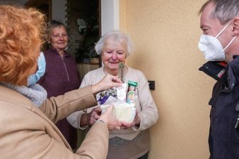 Ein Adventskorb für Frau Donat - Gemeinderäte auf Geschenketour: Claudia Elsner und Dirk Kärgling überreichen Hanna Donat ein Geschenkkörbchen. 