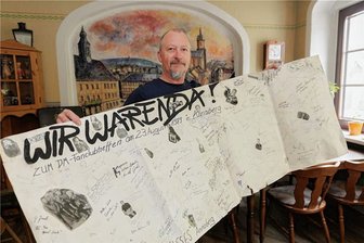 Ein Annaberger und seine unerschütterliche Liebe zu Depeche Mode - Erinnerungen an einen außergewöhnlichen Moment in Annaberg-Buchholz: Torsten Weiser mit dem großen Plakat des Depeche-Mode-Fanclubtreffens im August 1989, auf dem viele der Teilnehmer unterschrieben haben.