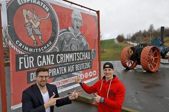 Ein Eispiraten-Stürmer, der am Kreisverkehr über ein Tor jubelt - Sie freuen sich über das Plakat: Medienchef Aaron Frieß (links) und Will Rudert.