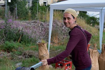 Ein Experiment gelingt in Mylau: Erstes Eisen aus dem Rennofen - Auf das Glutbett legt Nadine Holesch mit einer Kelle abwechselnd Holzkohle und Erz.