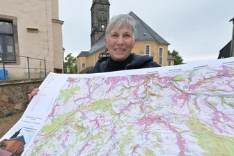 Ein Hauch von Asien in Kirchberg: Was eine besondere Wanderkarte mit dem einzigartigen Kirchturm zu tun hat - Sieglinde Eichert mit der limitierten Wanderkarte vor der Kirchberger Margarethenkirche. Anlässlich des Jubiläums „225 Jahre Turmbau“ sind davon 225 Exemplare gedruckt worden.
