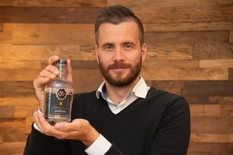 Ein Hauch von Waldgeschmack: Was den neuen Gin vom Tannenhaus in Schöneck so besonders macht - Tobias Werner, Geschäftsführer vom Hotel und Restaurant Tannenhaus in Schöneck, zeigt den hauseigenen Gin.