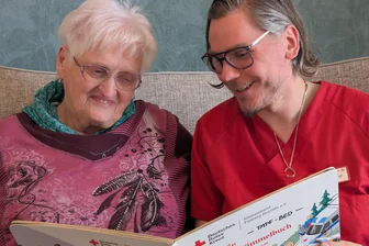 Ein Lachen, das den Raum erfüllt: Wie der DRK-Treff Brand-Erbisdorf Lebensfreude schenkt - „Ich freue mich, dass hier was los ist. Es tut mir gut.“ - Irene Decker mit DRK-Mitarbeiter Ralf Morgenstern beim Buchlesen.