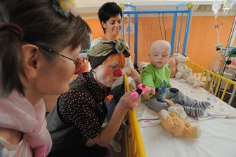 Ein paar Minuten Glück - Mit einer Fingerpuppe weckt Clown Erna - Annemarie Schroeter - Pauls Aufmerksamkeit. Der Anderthalbjährige aus Penig leidet an Leukämie. Die Clowns, ganz links Floh - alias Heike Nowotsch -, amüsieren auch Pauls Mutter Maria Schmidt.
