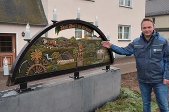Ein Schwibbogen für das ganze Jahr - Niederdorfs Bürgermeister Stephan Weinrich am Schwibbogen vorm Schnitzerheim.