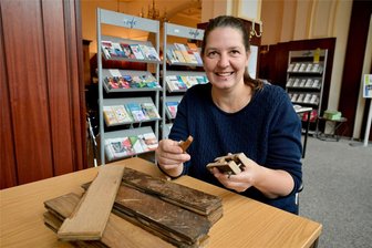 Ein Stück erzgebirgische Bahngeschichte: Was aus altem Parkett entstehen kann - Annett Beier von der Initiative Kulturgüterbahnhof Niederschlema mit Teilen des Parketts, aus denen am Samstag Flaschenöffner gefertigt werden sollen.