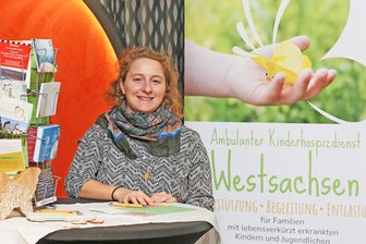 Ein Tag für kleine Helden: Wie Zwickau Familien mit besonderen Herausforderungen sichtbar macht - Lisa Kertzscher vom Ambulanten Kinderhospizdienst am Info-Stand im „Astoria“-Foyer.