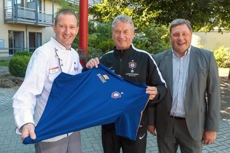 Ein Trikot für den Küchenchef - Im Beisein von Verwaltungsleiter Ferdinand Keller überreichte Ex-Fußballer Holger Erler an Küchenchef Erik Günther (v. r.) das Aue-Trikot.