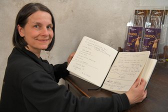 „Ein wunderbarer Ort der Ruhe“: Freiberger Dom als Besuchermagnet - Jana Tschapek vom Büro Musik und Tourismus des Doms St. Marien zu Freiberg mit dem Gästebuch