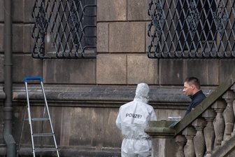 Einbruch in Grünes Gewölbe: Polizei stellt Tat nach - Polizisten neben dem durchtrennten Gitterfenster des Grünen Gewölbes am Residenzschloss.