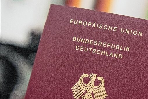 Einbürgerung soll leichter werden: Diese Änderungen sind vorgesehen - Eine aus Indien stammende Frau hält ihren neuen Pass in die Kamera. Nach Deutschland eingewanderte Menschen, sollen künftig - sofern sie ein qualifiziertes Aufenthaltsrecht haben - nach fünf, nicht wie bisher nach acht Jahren eingebürgert werden können.