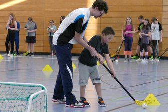 Eine Auszeit voller Sport und Gespräche - Neben weiteren Sportarten stand in der Turnhalle des Zschopauer Berufsschulzentrums auch Floorball auf dem Programm. Hier erklärt Fabian Göbel einem Teilnehmer des Feriencamps die Schusstechnik. 