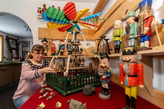 Eine besondere Pyramide aus Schöneck sorgt in Werda für eine Überraschung - Die s-förmigen Säulen an Pyramiden sind nur im Raum Schöneck bekannt. Michaela Gerbeth stellt gerade die Figuren auf den Drehturm. Er ist in der Werdaer Heimatstube zu sehen.