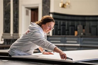 Eine Vogtländerin ist Deutschlands beste Raumausstatterin - Im Schwurgerichtssaal am Zwickauer Landgericht bringt Rahel Dörfel eine akustische Raumbespannung an. Dafür schneidet sie große Schaumstoffplatten zurecht und und verleimt sie an die Wand.