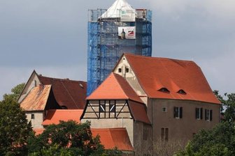 Eingerüsteter Bergfried weckt Neugier - Der angesichts von Sanierungsarbeiten eingerüstete Bergfried der Burg Schönfels zieht Neugierige zu dem alten Gemäuer. 
