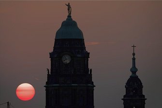 Einmal frei am Buß- und Bettag ab 124,80 Euro aufwärts - wackelt nun Sachsens Sonderweg? - Hinter Rathausturm (l) und Kreuzkirche versinkt die Sonne am Dresdner Abendhimmel. Endet nun auch Sachsens Sonderweg beim Buß- und Bettag? Selbst die CDU will die Arbeitnehmer im Freistaat bei der Pflegeversicherung nicht mehr stärker belasten als Arbeitgeber. Foto: Sebastian Kahnert/dpa-Bildfunk