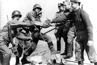 Einmaliger Feiertag 2025 in Deutschland: Nur ein Bundesland darf sich freuen - Ein Foto mit Symbolkraft: US-amerikanische (l.) und sowjetische Soldaten reichen sich am 25. April 1945 auf den Trümmern einer Elbbrücke bei Torgau die Hände. Am 8. Mai 1945, kapitulierte das NS-Reich dann: Dieses Datum gilt seither gemeinhin als Tag der Befreiung.