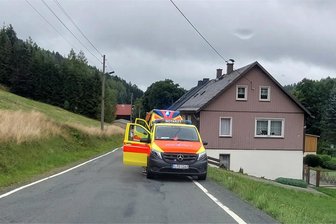 Einsatz wegen eines Notfalls in Zwota: Kriminalpolizei ermittelt - Einsatzfahrzeuge der Rettungskräfte des DRK an der Bergstraße in Zwota.