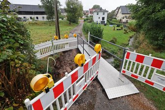 Einsturzgefährdete Brücke in Rödlitz kurzfristig abgerissen: Engpass bei Heizöl droht - Die Polsterbrücke ist weg, es gibt nur noch eine provisorische Fußgängerbrücke. Hier der Blick in Richtung Hauptstraße. Schwierigkeiten gibt es bei den Anliegern auf der gegenüberliegenden Bach-Seite.