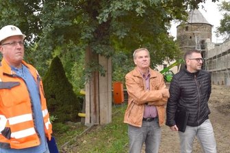 Einweihung der sanierten Burgruine für Ende Mai geplant - Spesa-Projektleiter Gerald Jech (links) und Bauplaner Thomas Schafferhans (2. von rechts) informierten am Dienstag über den Stand der Sanierung auf der Burgruine Elsterberg. Bei dem Rundgang dabei waren unter anderem der stellvertretende Vorsitzende des Heimatvereins, Klaus Hiemisch, und Bürgermeister Sandro Bauroth (rechts). Im Hintergrund ist die untere Schlossmauer zu sehen, die derzeit noch eingerüstet ist.