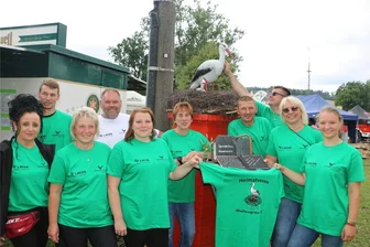 Einwohner von Wallengrün im Vogtland feiern ihr Storchenpaar und Walli - An ihren grünen T-Shirts waren die vielen Heimatverein-Mitglieder in Wallengrün zu erkennen. Auf dem Rücken prangt natürlich ein Storch.